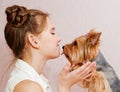 Smiling little girl child schoolgirl holding and playing with pet dog yorkshire terrier Royalty Free Stock Photo