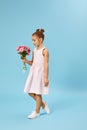 adorable smiling little girl holding bouquet of roses Royalty Free Stock Photo