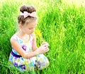 Adorable smiling little girl on the meadow smelling the flowers Royalty Free Stock Photo