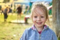 Adorable smiling little girl in park with playground in background Royalty Free Stock Photo
