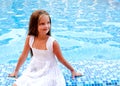 Adorable smiling little girl sitting near the swimming pool Royalty Free Stock Photo