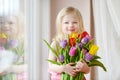 Adorable smiling little girl with tulips