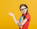 Adorable student girl  holding the books  and showing something Royalty Free Stock Photo