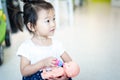 Sweet Asian little baby child playing doll, feeding bottle milk to baby doll