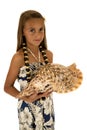 Adorable tan girl holding seashell wearing an island style dress Royalty Free Stock Photo