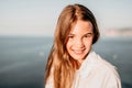 Adorable teenage girl outdoors enjoying sunset at beach on summer day. Close up portrait of smiling young romantic Royalty Free Stock Photo