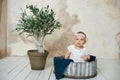 Adorable Ten month old newborn baby girl sitting in a wooden bucket. old baby in bedroom. father& x27;s day. father and daughter Royalty Free Stock Photo