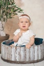 Adorable Ten month old newborn baby girl sitting in a wooden bucket. old baby in bedroom. father& x27;s day. father and daughter Royalty Free Stock Photo