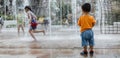 An adorable toddler Asian boy 1-year-old standing and enjoy to see outdoor public fountains a water splashing for the first time