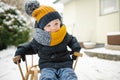 Adorable toddler boy having fun in a backyard on snowy winter day. Cute child wearing warm clothes playing in a snow Royalty Free Stock Photo