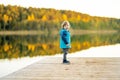 Adorable toddler boy having fun by the Gela lake on sunny fall day. Child exploring nature on autumn day in Vilnius, Lithuania Royalty Free Stock Photo