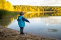 Adorable toddler boy having fun by the Gela lake on sunny fall day. Child exploring nature on autumn day in Vilnius, Lithuania Royalty Free Stock Photo