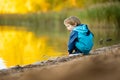 Adorable toddler boy having fun by the Gela lake on sunny fall day. Child exploring nature on autumn day in Vilnius, Lithuania Royalty Free Stock Photo