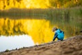 Adorable toddler boy having fun by the Gela lake on sunny fall day. Child exploring nature on autumn day in Vilnius, Lithuania Royalty Free Stock Photo