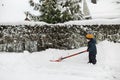 Adorable toddler boy helping his grandfather to shovel snow in a backyard on winter day. Cute child wearing warm clothes playing Royalty Free Stock Photo