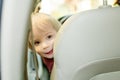 Adorable toddler boy playing in the driver`s seat. Cute little son sitting in fathers car