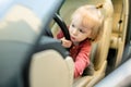 Adorable toddler boy playing in the driver`s seat. Cute little son sitting in fathers car