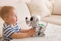 Adorable toddler boy playing with interactive toy. Child with toy robot dog. indoors. Activities for small children. Communication