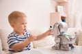 Adorable toddler boy playing with interactive toy. Child with toy robot dog. indoors. Activities for small children. Communication