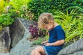 Adorable toddler boy sitting on the bench and playing with smartphone. Child learning how to use smartphone. Boy texting on the ph Royalty Free Stock Photo