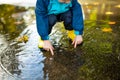 Adorable toddler boy wearing yellow rubber boots playing in a a puddle on sunny autumn day in city park. Child exploring nature. Royalty Free Stock Photo