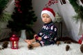 Adorable toddler child, boy, having his christmas portrait taken in decorated room with teepee, snowman and other chirstmas Royalty Free Stock Photo