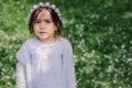 Adorable toddler child girl in light blue dressy outfit walking and playing in blooming spring garden