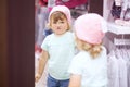 Cute little girl choosing clothes in the shop, fitting knitted. Royalty Free Stock Photo