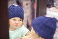 Cute little girl choosing clothes in the shop, fitting knitted hat. Royalty Free Stock Photo