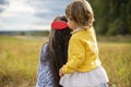 Adorable toddler girl combing her mom`s hair outdoors outdoors on a sunny day Royalty Free Stock Photo