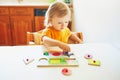 Adorable toddler girl doing wooden puzzle