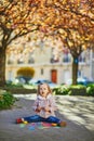 Adorable toddler girl drawing with colorful chalks on asphalt Royalty Free Stock Photo