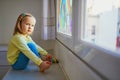 Adorable toddler girl drawing rainbow on window glass Royalty Free Stock Photo