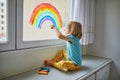 Adorable toddler girl drawing rainbow on window glass Royalty Free Stock Photo