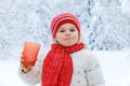 Adorable toddler girl drinking hot chocolate in winter forest. Happy healthy child with cup of steaming cocoa or tea Royalty Free Stock Photo