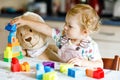 Adorable toddler girl with favorite plush bunny playing with educational toys in nursery. Happy healthy child having fun Royalty Free Stock Photo