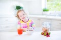 Adorable toddler girl having breakfast drinking juice Royalty Free Stock Photo