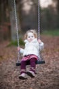 Adorable toddler girl having fun on a swing Royalty Free Stock Photo