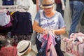 Cute little girl and her grandmother choosing clothes in the shop. Royalty Free Stock Photo