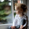 Adorable toddler girl looking though the window Royalty Free Stock Photo