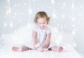 Adorable toddler girl playing between Christmas lights Royalty Free Stock Photo