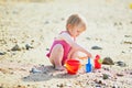 Adorable toddler girl playing with sand on the beach Royalty Free Stock Photo