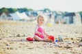 Adorable toddler girl playing with sand on the beach Royalty Free Stock Photo