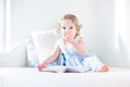 Adorable toddler girl reading book in rocking chair Royalty Free Stock Photo