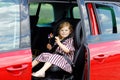 Adorable toddler girl sitting in car seat and looking out of the window on nature and traffic. Little kid traveling by Royalty Free Stock Photo