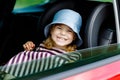 Adorable toddler girl sitting in car seat and looking out of the window on nature and traffic. Little kid traveling by Royalty Free Stock Photo