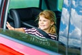 Adorable toddler girl sitting in car seat and looking out of the window on nature and traffic. Little kid traveling by Royalty Free Stock Photo