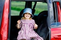 Adorable toddler girl sitting in car seat and looking out of the window on nature and traffic. Little kid traveling by Royalty Free Stock Photo