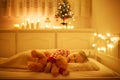 Adorable toddler girl sleeping with her teddy bear under the Christmas tree Royalty Free Stock Photo