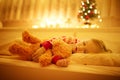 Adorable toddler girl sleeping with her teddy bear under the Christmas tree Royalty Free Stock Photo